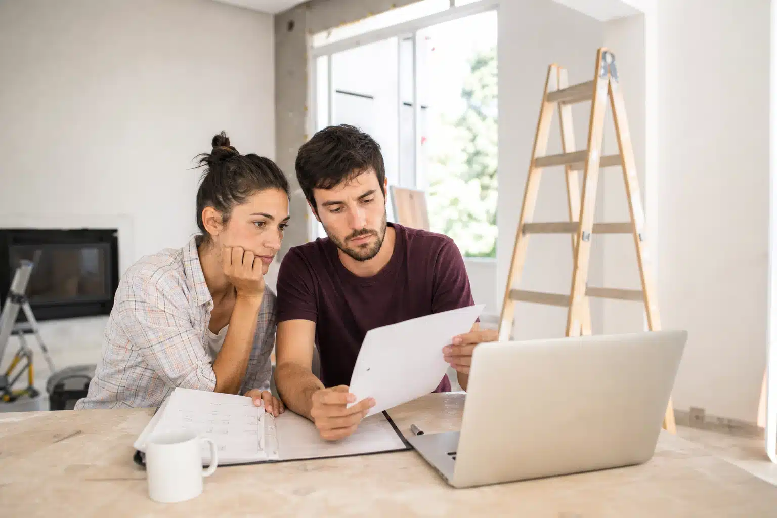 Couple examinant des papiers devant un ordinateur